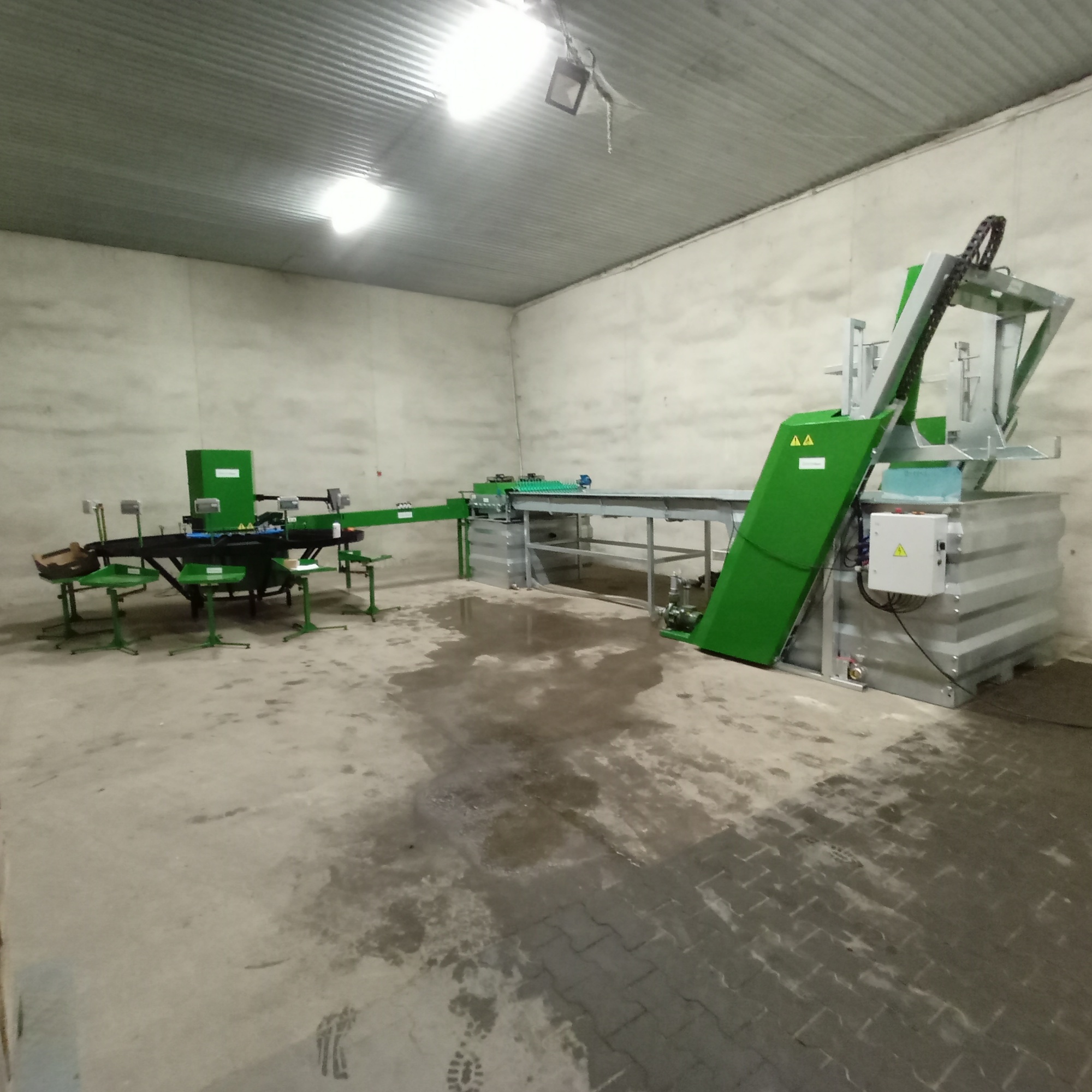 Linia do sortowania jabłek z przenośnikami i wodnym rozładunkiem w hali